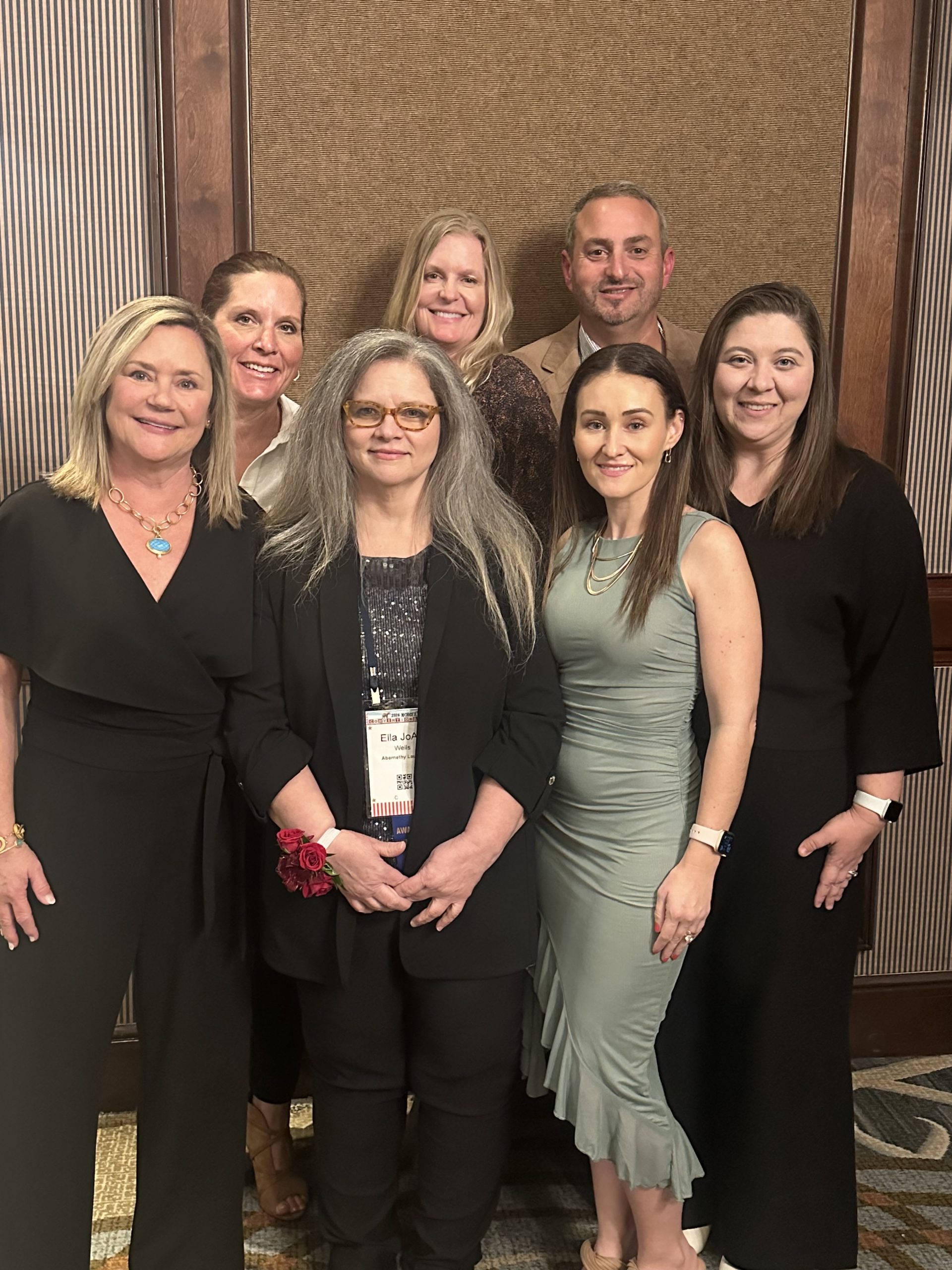 group of colleagues and family circled around an award winner at an industry dinner